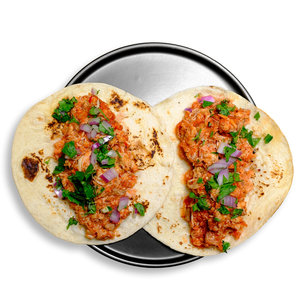 A duo of soft flour tortillas filled with juicy shredded chicken tinga, infused with roasted tomatoes, chipotle peppers, and garlic. Topped with a pop of red onion and leafy cilantro, these tacos are served on a sleek metal dish—perfect as a high-protein, flavor-packed healthy prepared meal for lunch, dinner, or meal prep rotation.
