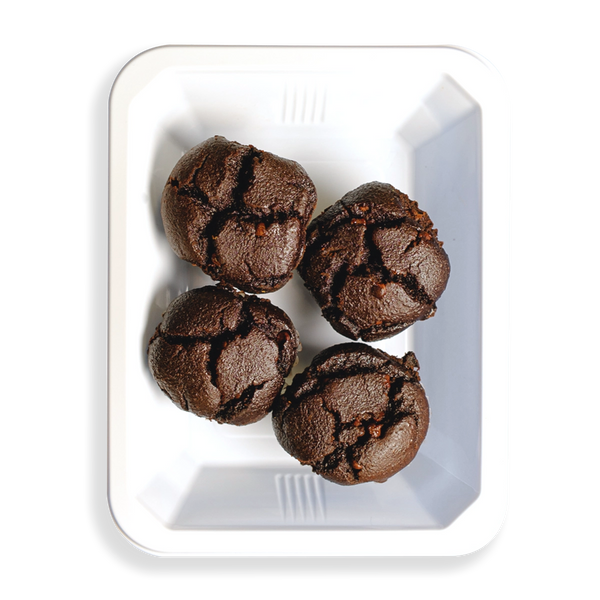 four really tasty looking muffins sit in this white togo container. the contrast of the black, I'm assuming chocolate flavored muffins, in the white container looks extremely appealing. If in fact this tasty looking food is very healthy than this is a game changer for those looking for healthy prepared meals.