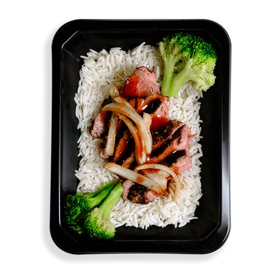 Thinly sliced flank steak over white rice, topped with low-sodium teriyaki sauce, broccoli, and julienned onions occupies the space of a black togo container. The broccoli is very green and this healthy prepared meal appears to be for those who are mindful of what they eat while not wanting to spare flavor and quality eating.