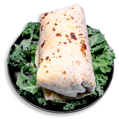 A hearty breakfast burrito wrapped in a golden, lightly toasted flour tortilla, nestled on a bed of crisp kale. This healthy prepared meal is stuffed with scrambled eggs, lean chipotle-seasoned ground turkey, melted pepper jack cheese, and diced green chiles—perfect for clean eating and convenient meal prep.
