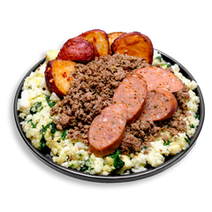This hearty health food plate presents a colorful medley of lean proteins and vegetables: finely crumbled turkey, tender egg whites blended with spinach, and a ring of roasted baby red potatoes. Finished with thick-cut rounds of bison sausage infused with jalapeño and cheddar, this balanced healthy prepared meal is designed for strength, flavor, and convenience.