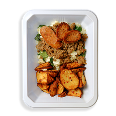 A vibrant and hearty meal arranged in a white takeout container, featuring seasoned ground turkey with a golden-brown sear layered over fluffy scrambled egg whites and tender, wilted spinach. On the side, crispy roasted red potatoes with caramelized edges bring a satisfying crunch. The dish is topped with slices of bison jalapeño cheddar sausage, dotted with melted cheese and green jalapeño pieces for a spicy, savory kick. Perfect for anyone short on time but craving a flavorful, wholesome meal.