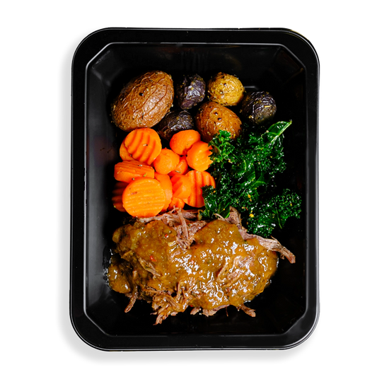 a medly of carrots, beef, greens, and roasted potatoes fill this togo container.  This appears to be a perfect meal designed for someone who wants to eat healthy but is busy and wants healthy food delivered to their location.