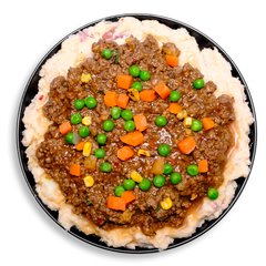 A nutritious twist on shepherd’s pie: lean bison simmered in a rich, garlic- and parmesan-seasoned sauce rests atop a velvety bed of mashed red potatoes and cauliflower. The dish bursts with fresh vegetables—crisp peas, diced carrots, charred corn, celery, and green onions—creating a balanced, flavor-rich healthy prepared meal.