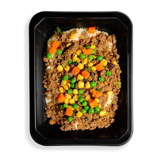 A hearty to-go meal with lean ground bison, red potatoes, and mixed vegetables like peas, carrots, cauliflower, and corn, all coated in a rich, creamy parmesan and garlic sauce. A healthy twist on the classic British dish is what this looks like to me.  The togo container appears to be designed for people who have food delivered or want to pick up healthy food in a store and are too busy to cook.