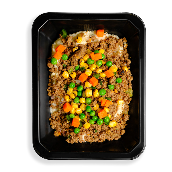 A hearty to-go meal with lean ground bison, red potatoes, and mixed vegetables like peas, carrots, cauliflower, and corn, all coated in a rich, creamy parmesan and garlic sauce. A healthy twist on the classic British dish is what this looks like to me.  The togo container appears to be designed for people who have food delivered or want to pick up healthy food in a store and are too busy to cook.