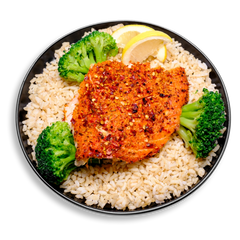 A colorful and health-conscious plate showcasing moist, flaky Atlantic salmon seasoned with roasted garlic, onion powder, and pink Himalayan salt. The salmon rests on a soft bed of brown rice, surrounded by crisp, steamed broccoli and bright lemon slices. This clean and energizing health food option makes for the perfect easy lunch or dinner.