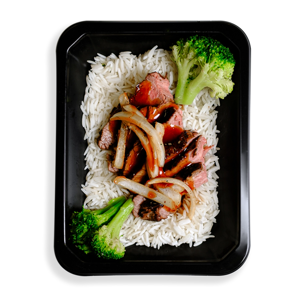 Thinly sliced flank steak over white rice, topped with low-sodium teriyaki sauce, broccoli, and julienned onions occupies the space of a black togo container.  The broccoli is very green and this healthy prepared meal appears to be for those who are mindful of what they eat while not wanting to spare flavor and quality eating.