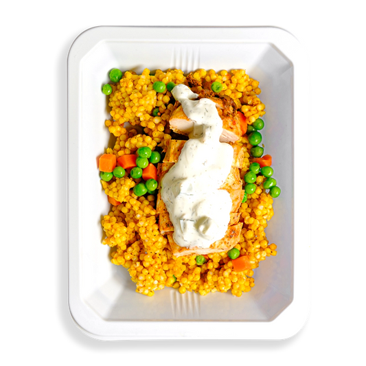 This to-go container is packed with vibrant, fresh ingredients—fluffy couscous loaded with green peas and bright orange carrots, all topped with tender chicken drizzled in a creamy white sauce. The bold colors and appetizing presentation make it an ideal choice for someone on the go who wants a healthy, flavorful meal without sacrificing convenience or taste.