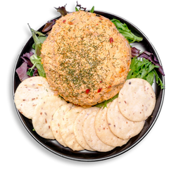Top-down view of a health food appetizer featuring a seasoned salmon spread blended with Greek yogurt, cream cheese, and herbs, garnished with dried dill. The spread is presented on leafy greens and served alongside a semi-circle of thin, crisp gluten-free crackers: ideal for healthy meal prep or a light, satisfying snack.
