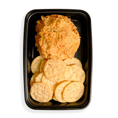 A large portion of shredded salmon with other tasty ingredients occupy half the black togo container with flavor while the remaining half contains very healthy looking crackers that are all in the shape of perfect circles.  This appears to be the perfect healthy snack for busy people on the go.