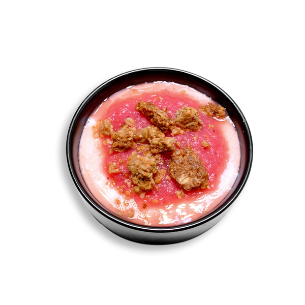 A 3/4 view of a vibrant bowl featuring a swirl of creamy Greek yogurt sweetened with agave nectar, layered beneath a bright pink strawberry-pineapple purée. Topped with clusters of golden-brown granola for crunch, this colorful, fruit-forward healthy prepared meal is a refreshing and protein-packed option for clean eating or breakfast meal prep.