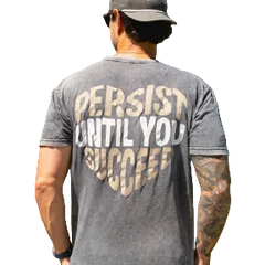 Man wearing a gray t-shirt with 'Persist Until You Succeed' text, standing outdoors.