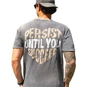 Man wearing a gray t-shirt with 'Persist Until You Succeed' text, standing outdoors.